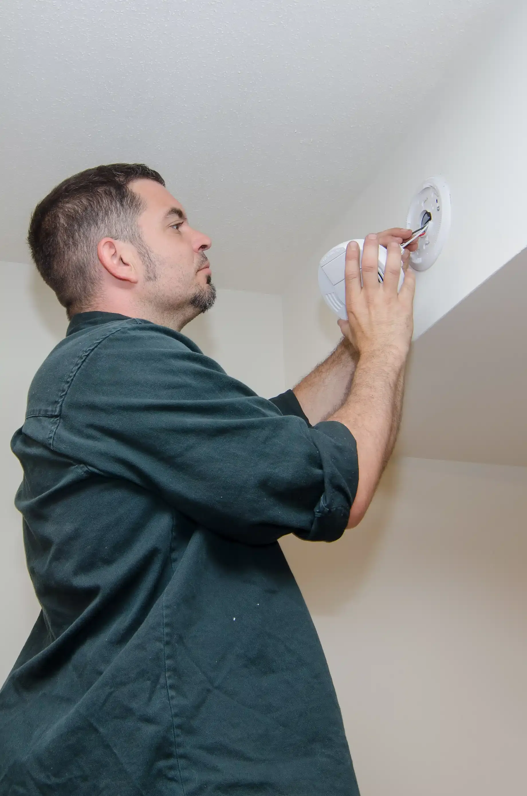 electrician installing carbon monoxide detector