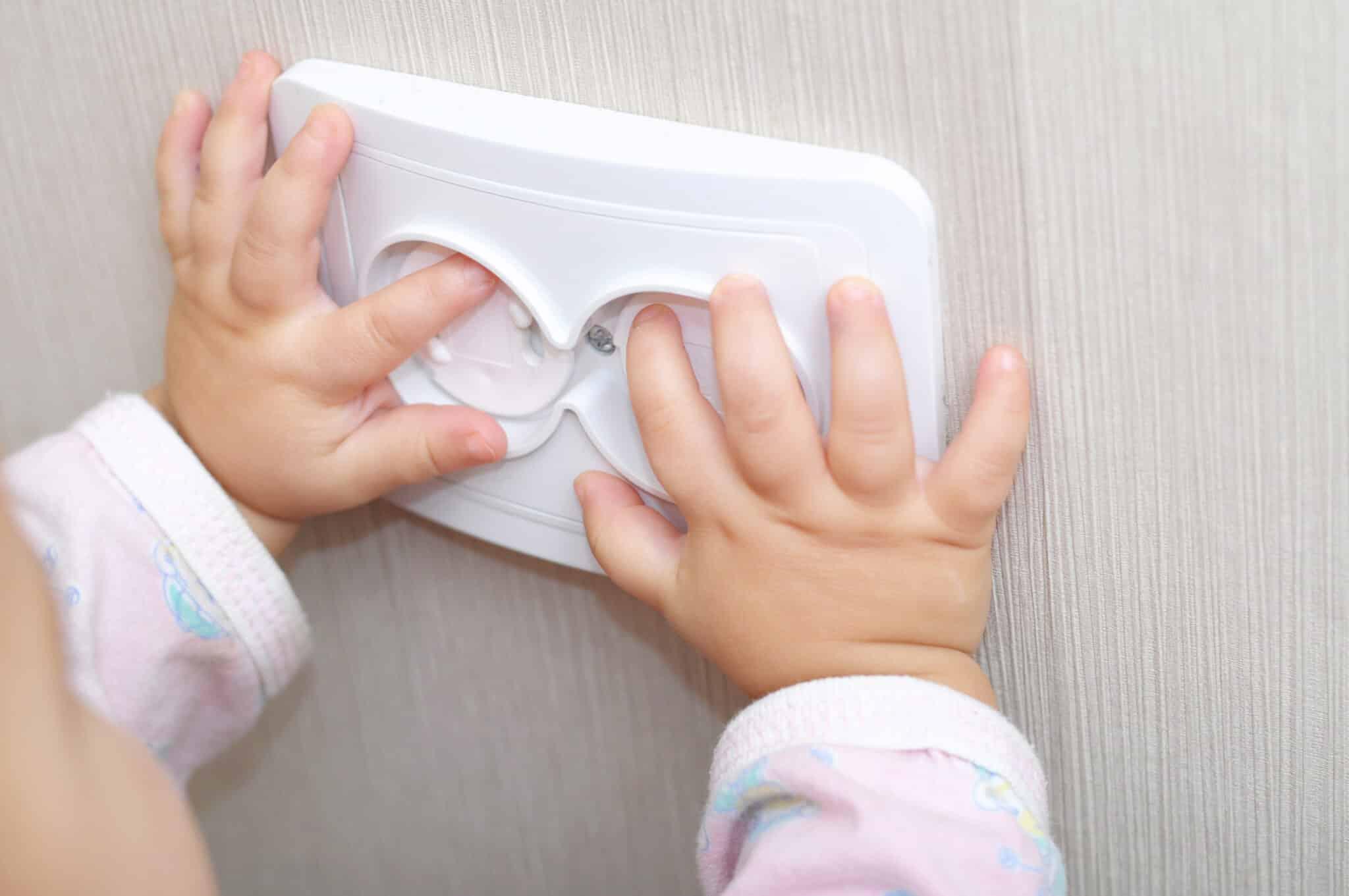 child putting hands on electrical outlet