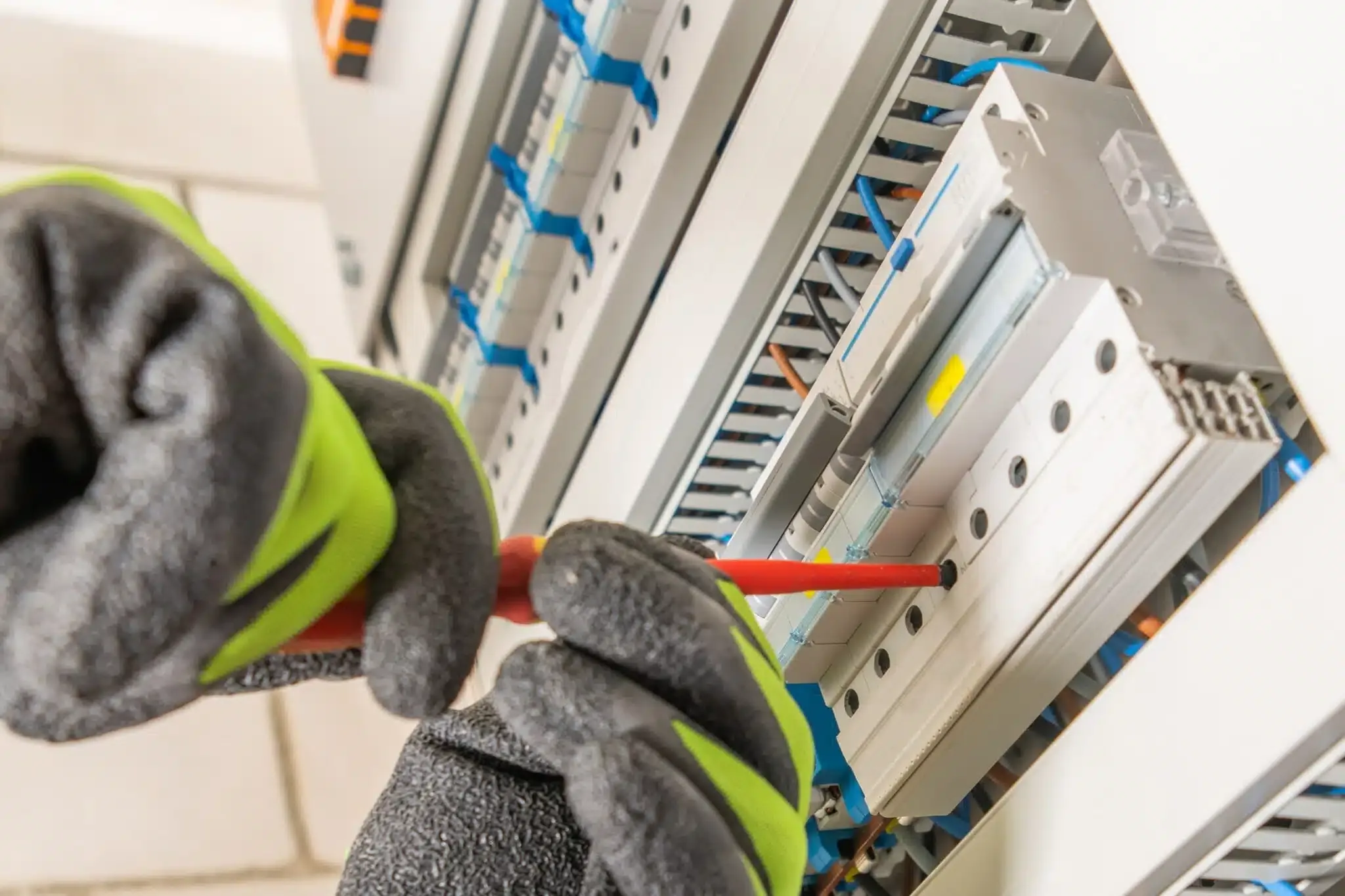 gloved hands working on electrical switches
