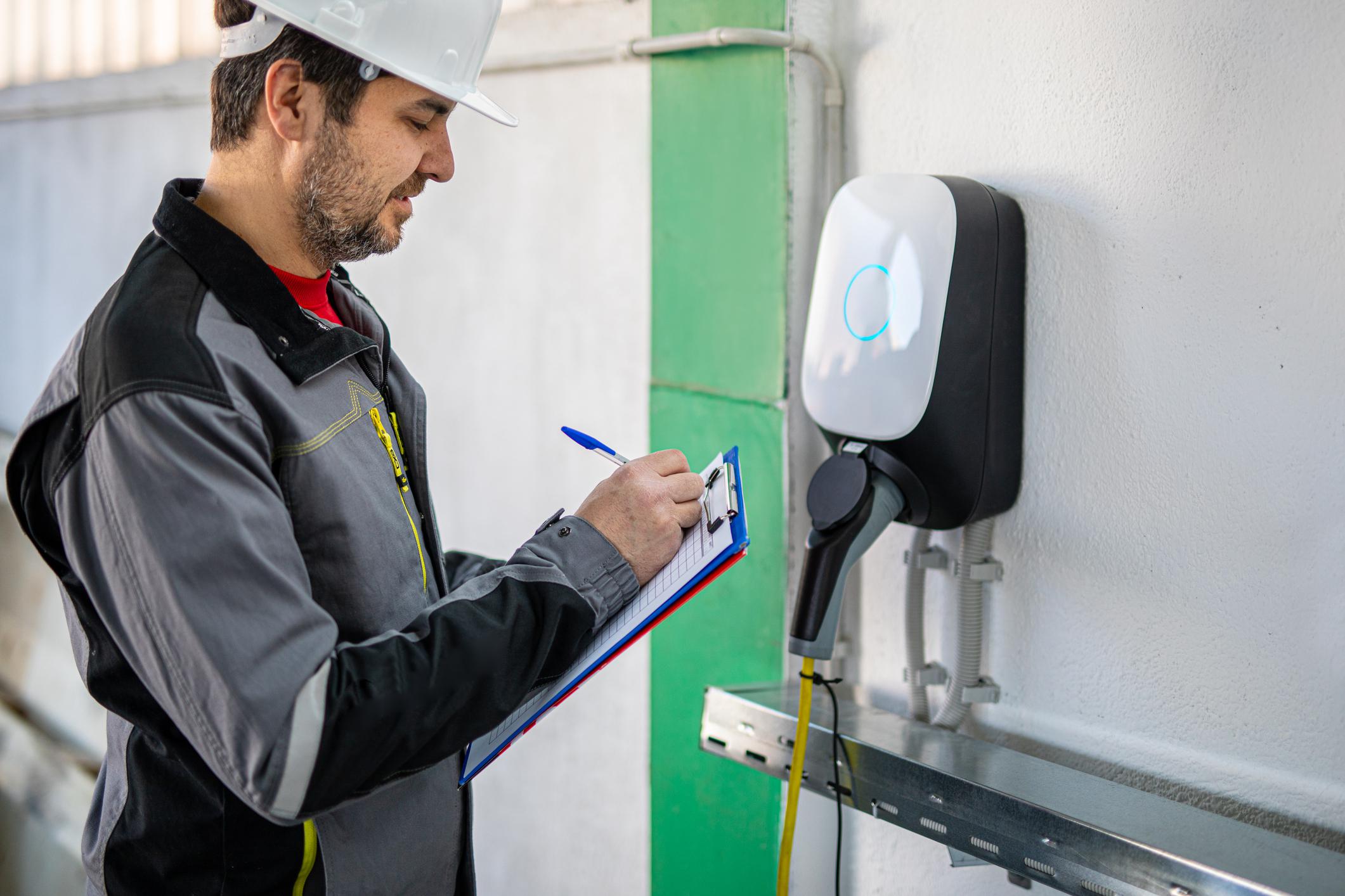 Engineer examining electric car charging station